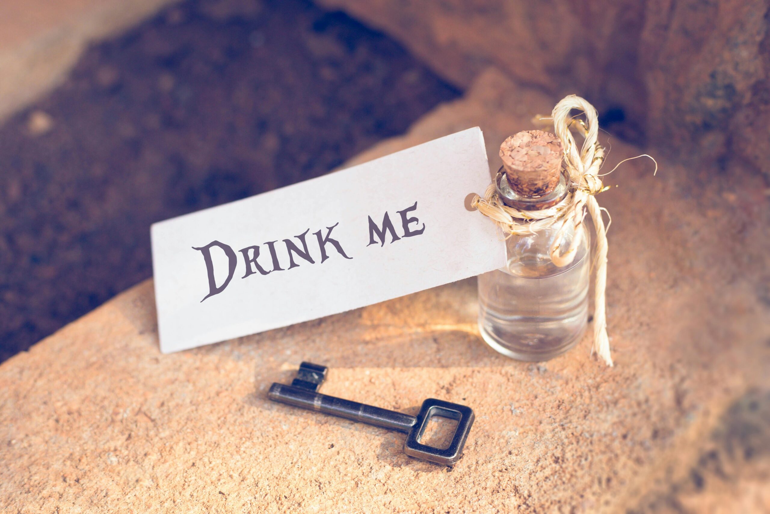 Whimsical image of a small potion bottle and key with 'Drink Me' tag, evoking fantasy tales.