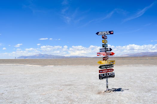 A bright signpost stands in a vast arid landscape with clear blue skies in Argentina.